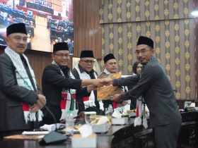 Alit Jamaludin, S.E. (Sekretaris F-PKB) memberikan berkas Pandangan Umum F-PKB