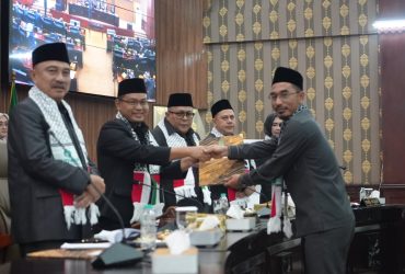 Alit Jamaludin, S.E. (Sekretaris F-PKB) memberikan berkas Pandangan Umum F-PKB
